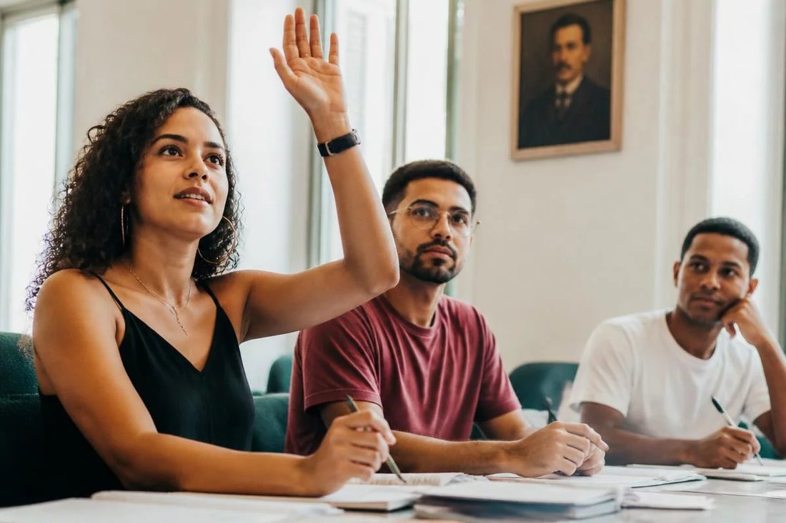 Facilitador em pé apontando para um argumento escrito no quadro durante a sessão