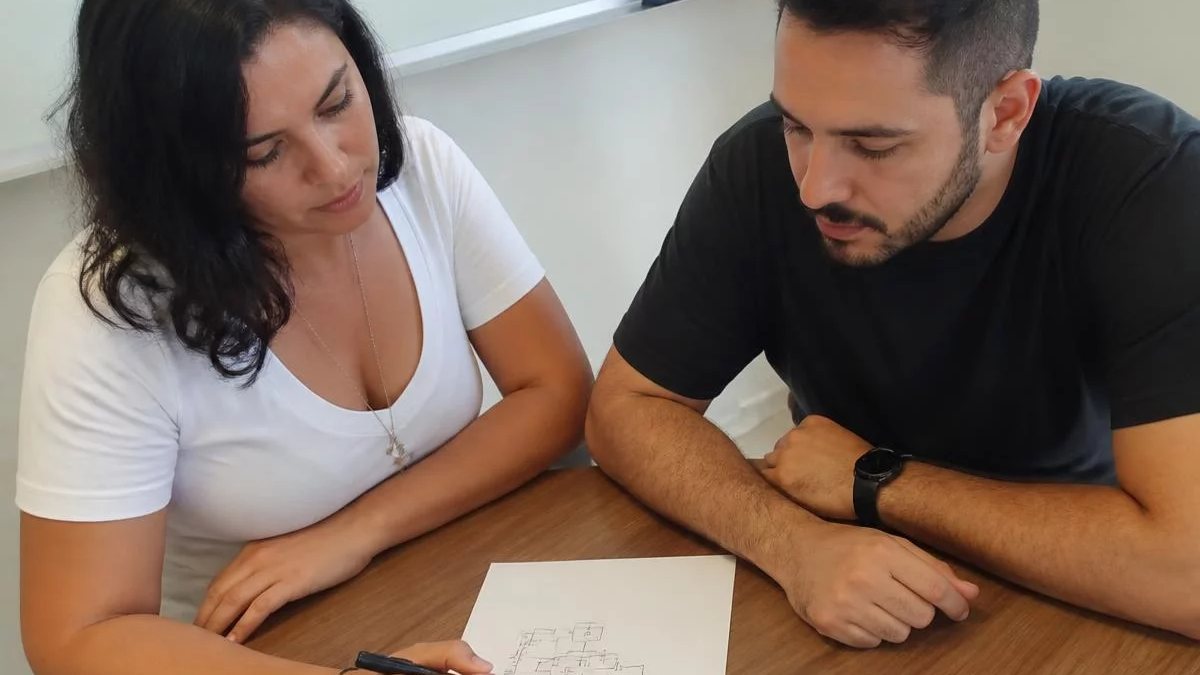 Participantes conferindo apontamentos num tablet apoiado na mesa durante o intervalo